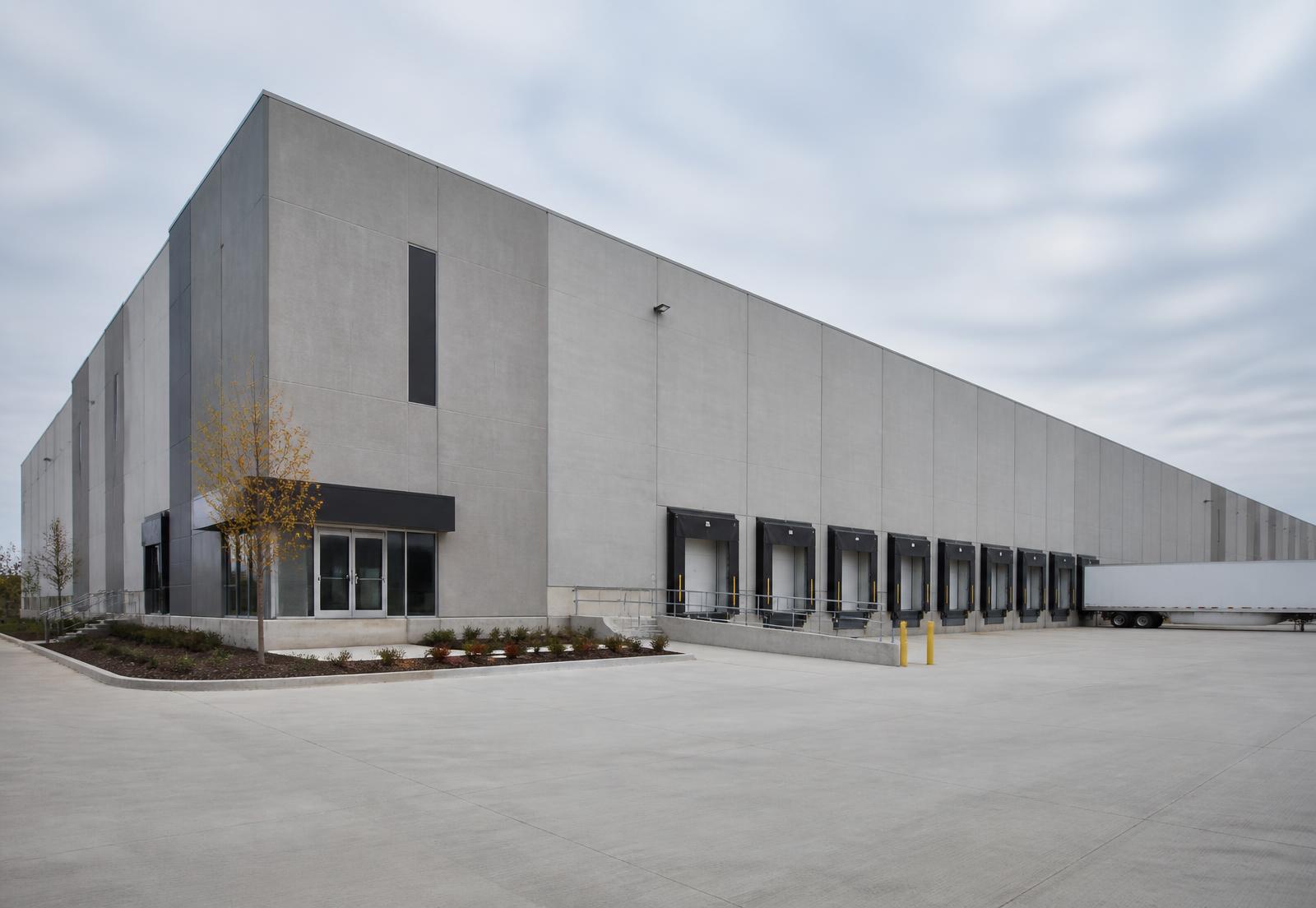 Concrete tilt-wall industrial building with loading docks and a paved yard